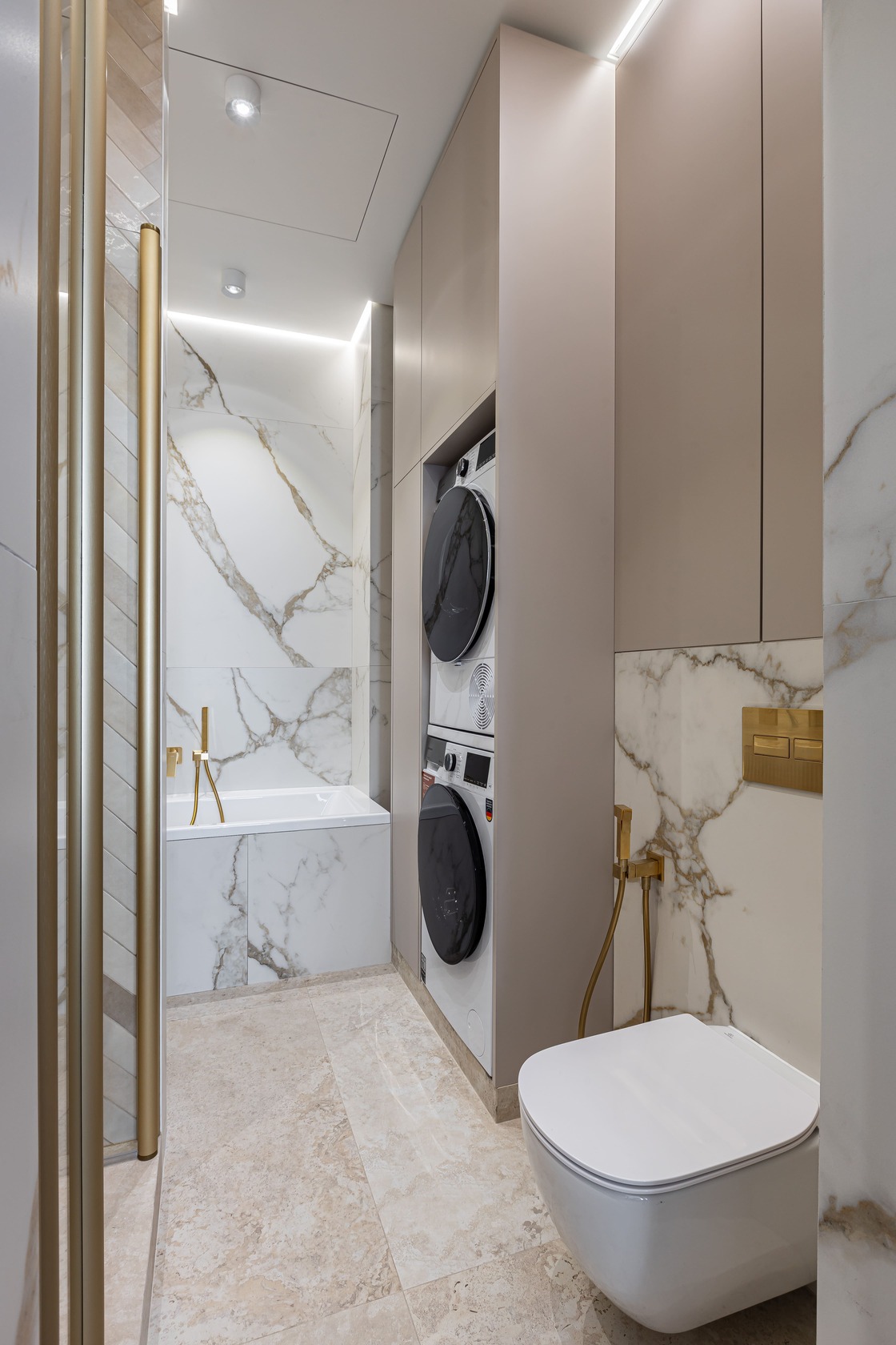 Marble-look bathroom with brass details and integrated laundry storage