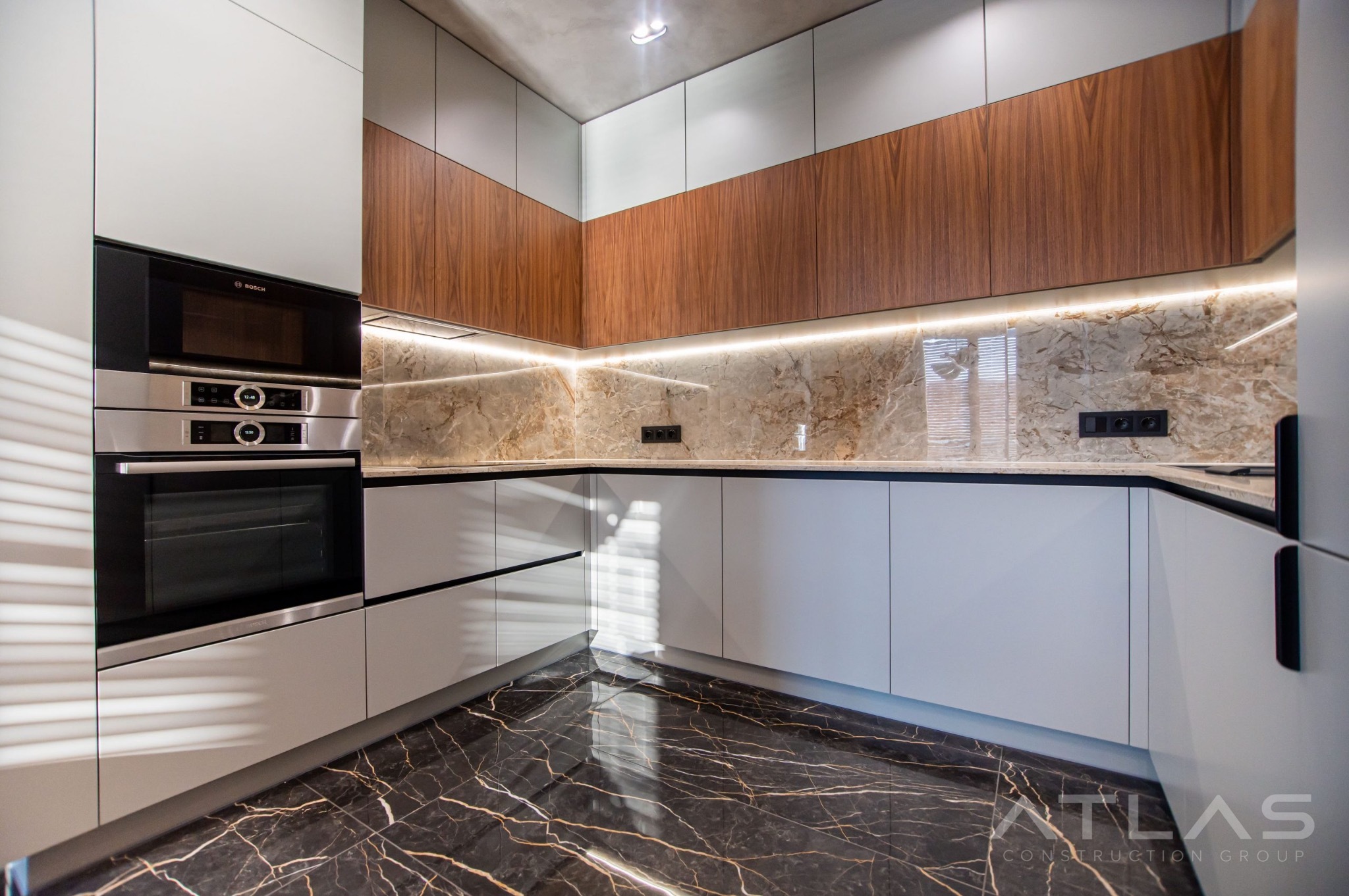 Custom kitchen with walnut cabinetry and marble backsplash