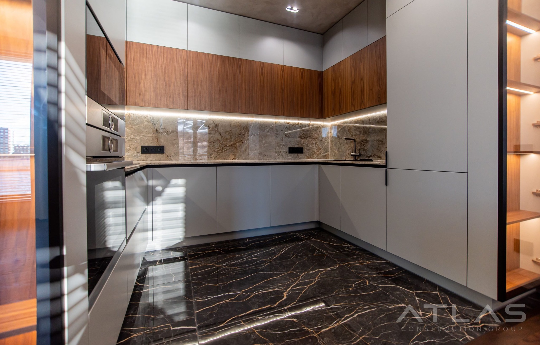 L-shaped kitchen with walnut cabinets and marble backsplash